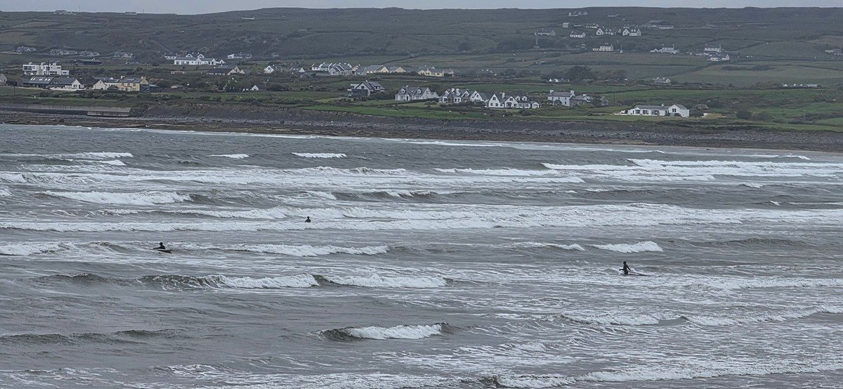 mushy waves on the main beach with a few braving the conditions